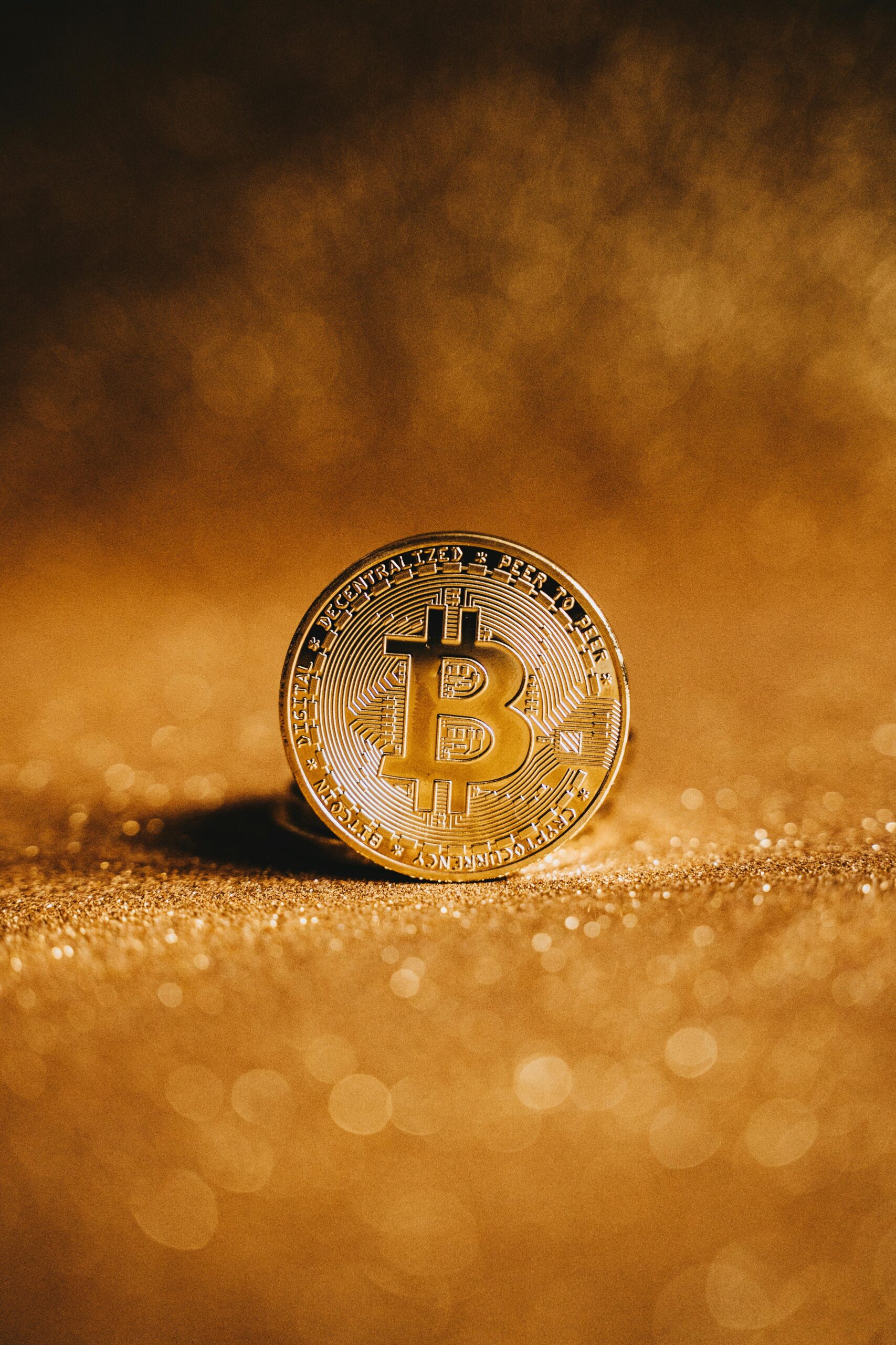 Close-up of a golden Bitcoin with a sparkling background, symbolizing digital finance.
